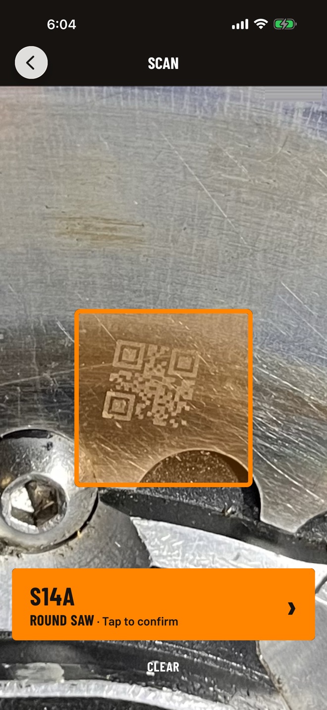 Kavrik app scan screen: the laser-etched QR on a roundsaw plate inside the scan frame, read as S14A, round saw, with a tap-to-confirm readout